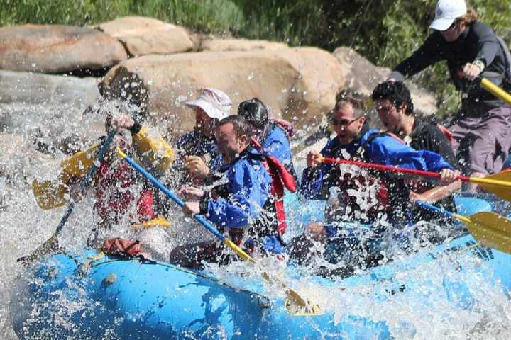 a group of people paddle the lower Animas River on a blue white water raft