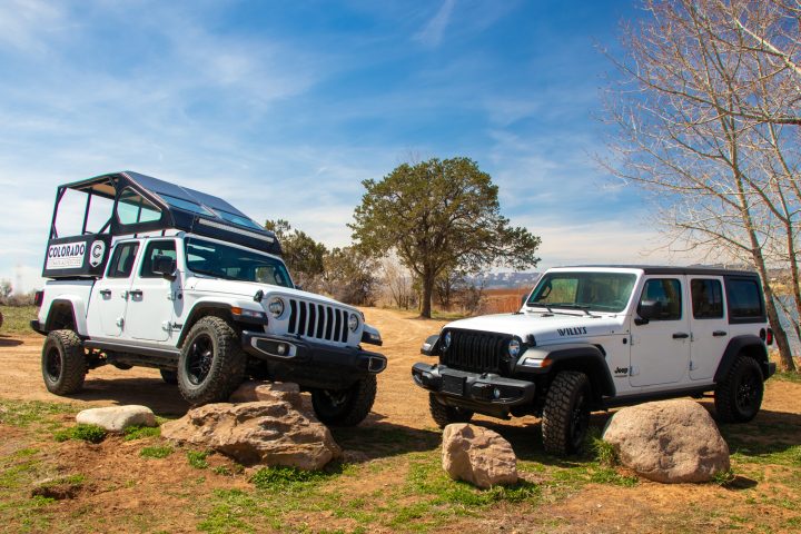 Two white jeeps parked next to each other