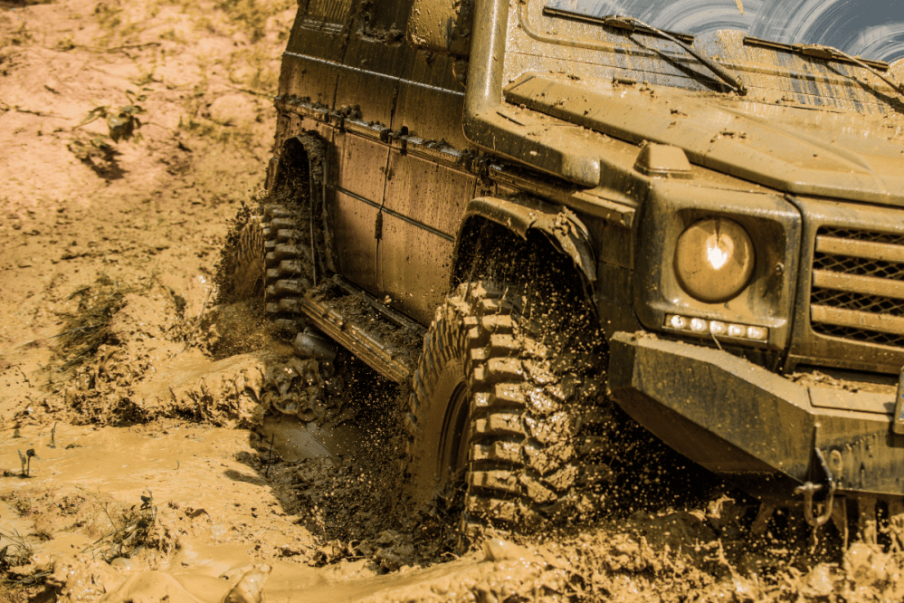 a car drives through a large muddy puddle